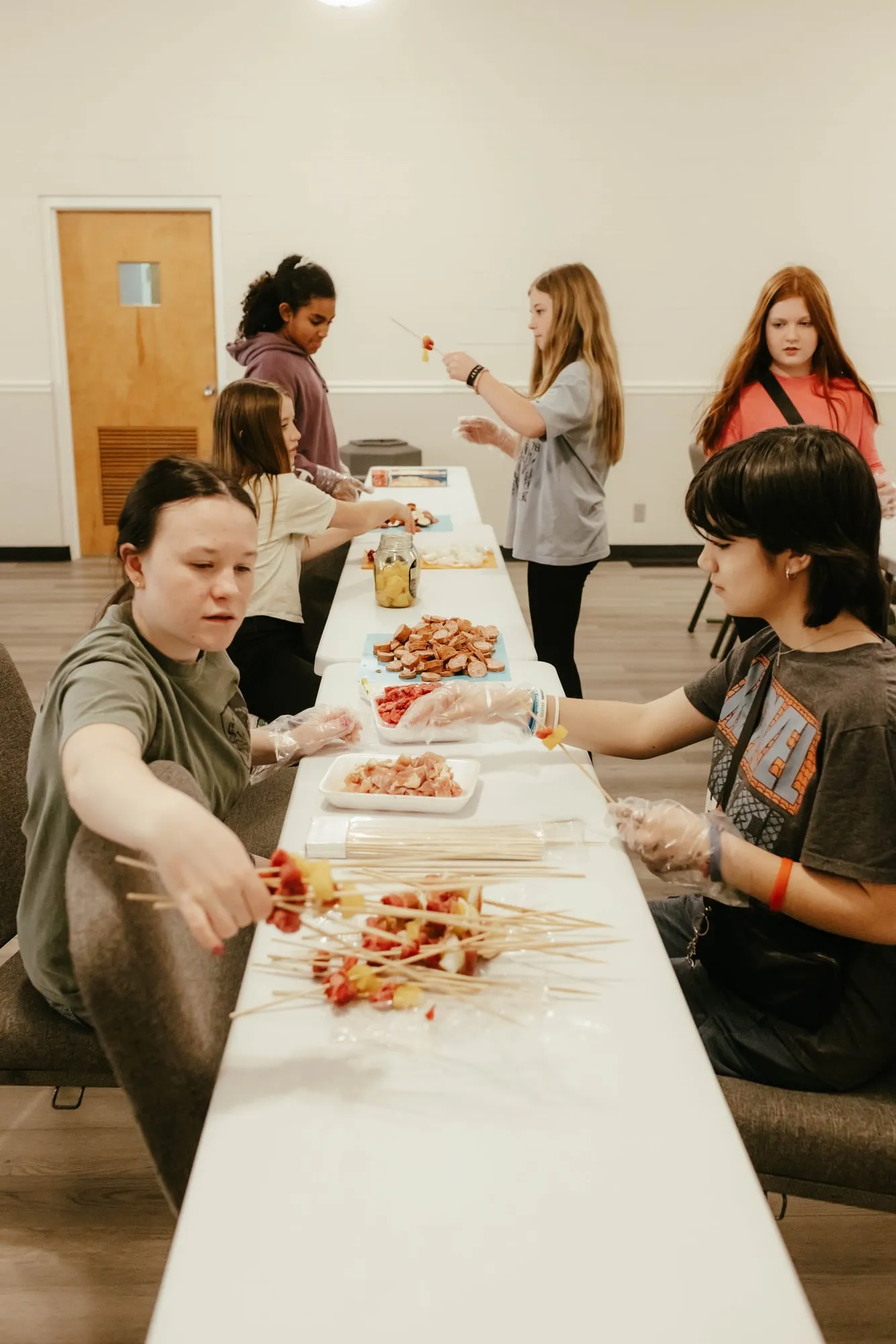 Students preparing fruit skewers in an elective class